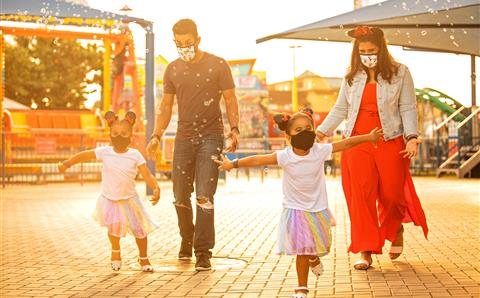 Family wearing masks and playing in bubbles in a theme park in Orlando, Florida. 