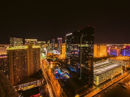 Nighttime aerial shot of Elara, a Hilton Grand Vacations Club and the Las Vegas Strip lit up. 