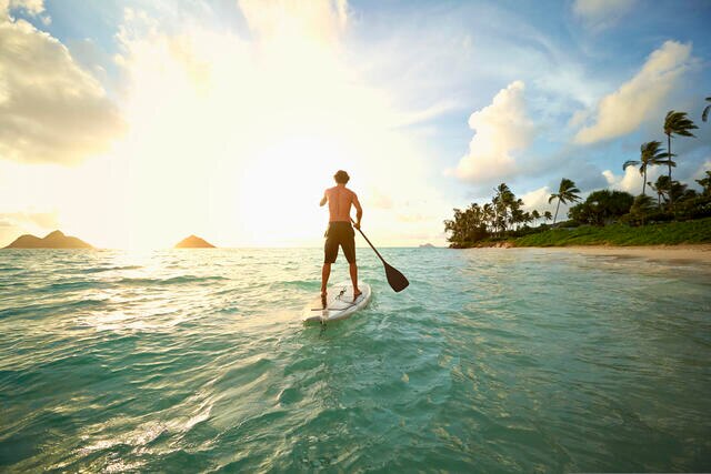 Man stand up paddle boarding while on vacation. 