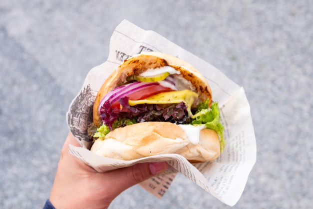 Point of view shot of a delicious casual-eats burger served in paper. 