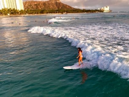 A Hilton Grand Vacations Owner surfs while on a working vacation in Oahu, Hawaii