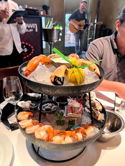 A seafood tower and live musician at an HGV Members Table dinner, hosted by Hilton Grand Vacations