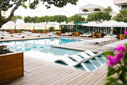 View of the poolside daybeds and contemporary lounge chairs at The Modern, a Hilton Vacation Club, Honolulu, Hawaii