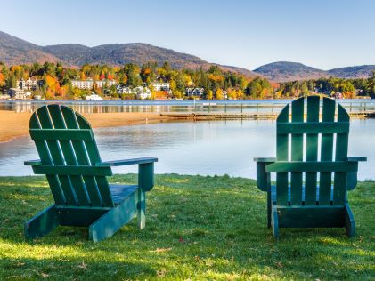 Two lounge chairs on the shore of Mirror Lake in Lake Placid, New York